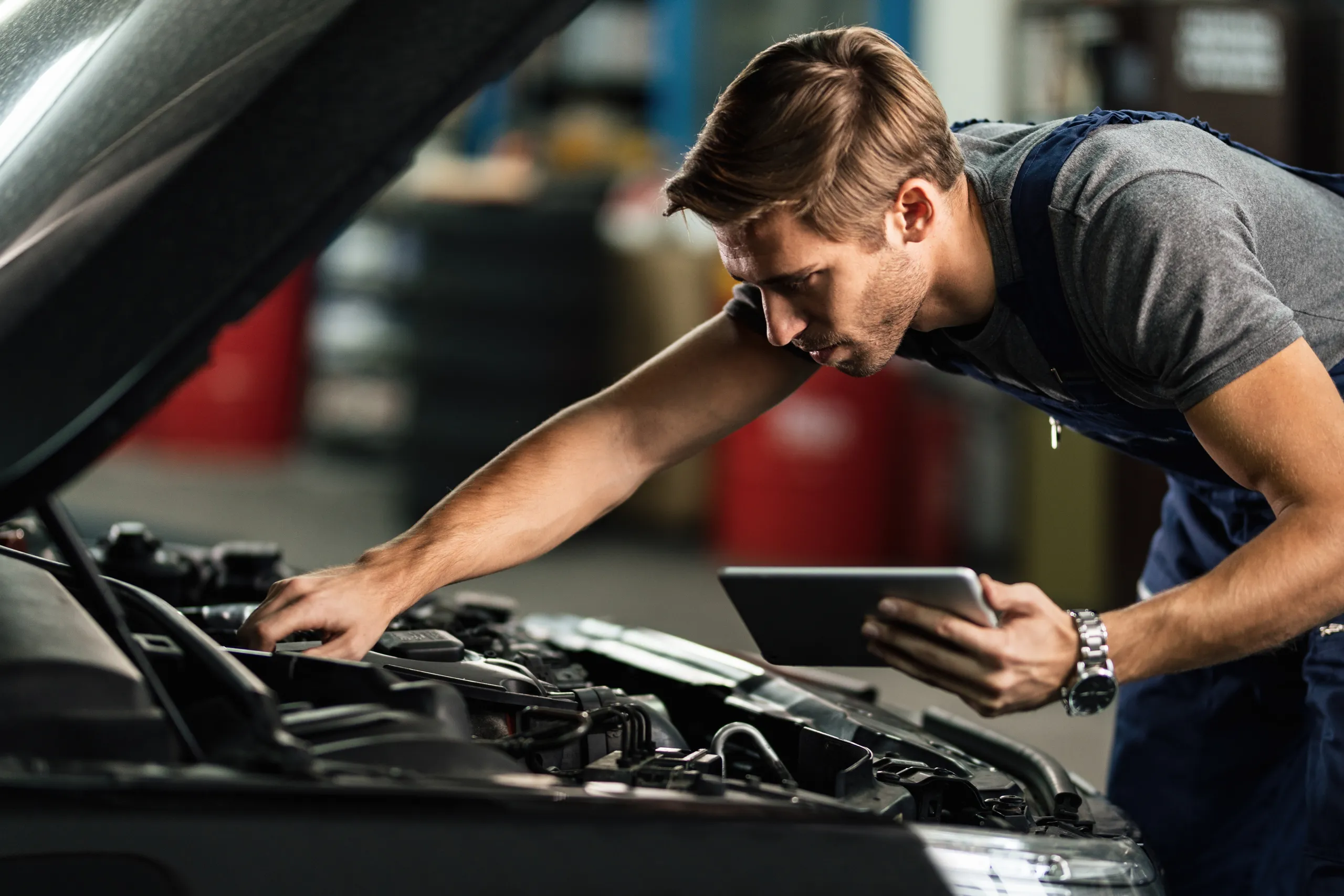 Um homem ruivo a verificar um carro