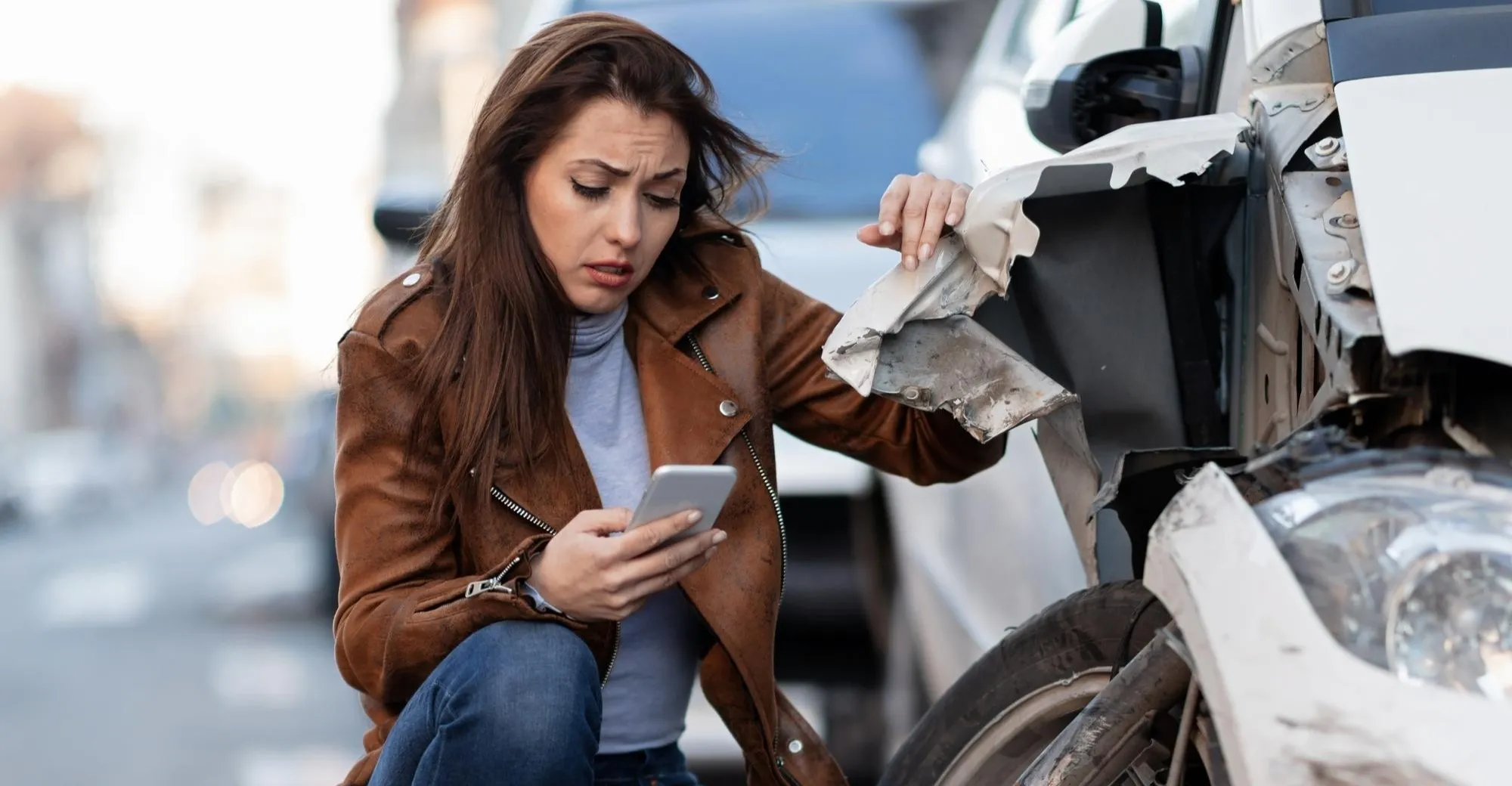 Uma mulher triste a enviar uma mensagem na berma de um carro